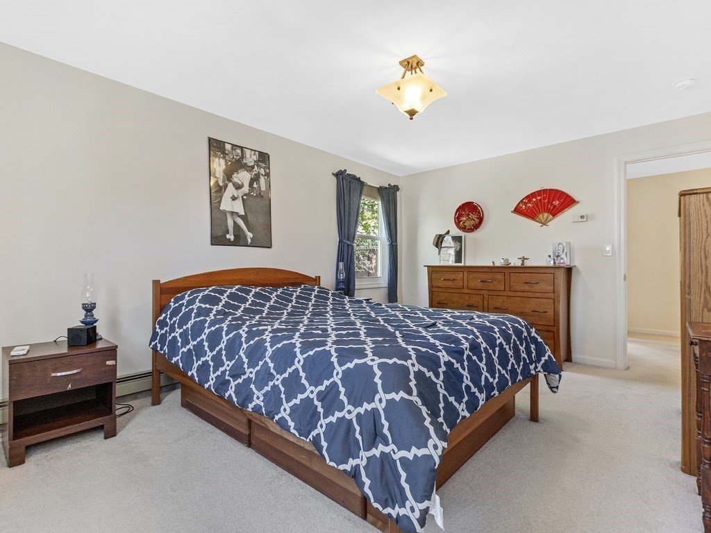 17 Central Street, Unit 2 Waltham, MA 02453 - Photo 22 of 39 a bedroom with a bed and a chandelier