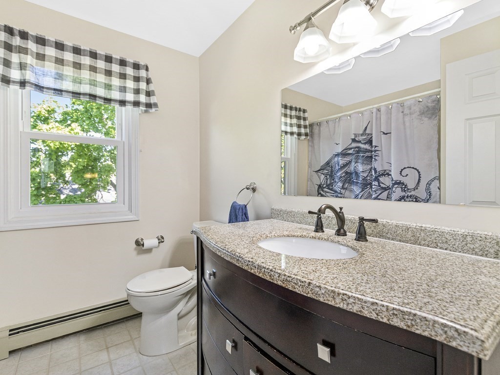 17 Central Street, Unit 2 Waltham, MA 02453 - Photo 27 of 39 a bathroom with a granite countertop sink a toilet and mirror