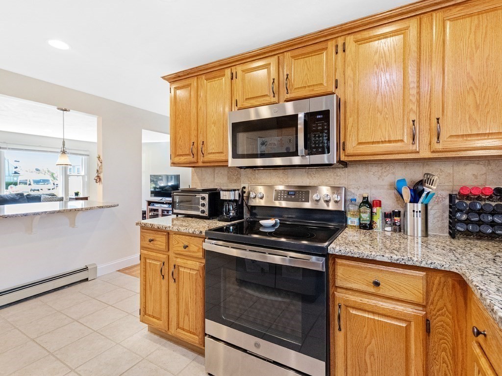 17 Central Street, Unit 2 Waltham, MA 02453 - Photo 5 of 39 a kitchen with granite countertop cabinets stainless steel appliances a sink and a window
