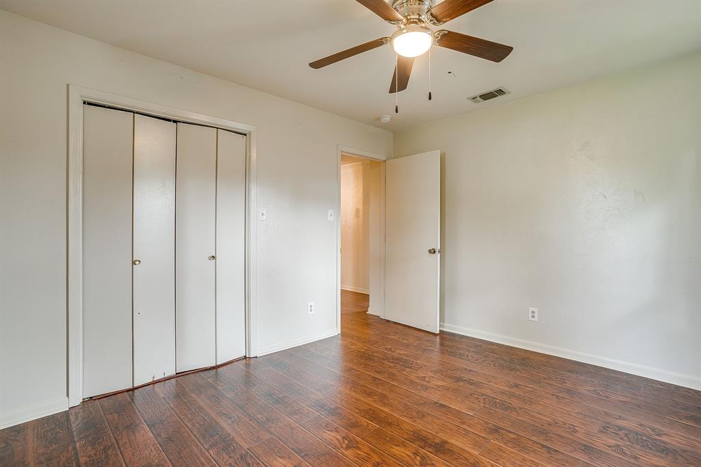 709 North Ave B Springtown, TX 76082 - Photo 16 of 32 an empty room with wooden floor fan and windows