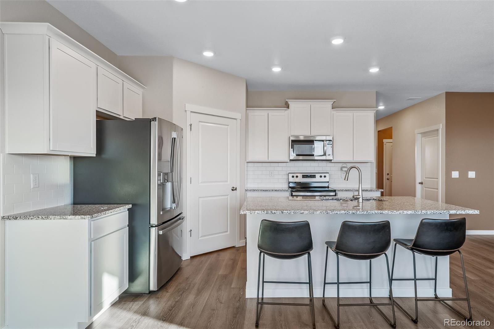 3018 Belleville Ridge Road Elizabeth, CO 80107 - Photo 13 of 32 a kitchen with stainless steel appliances a refrigerator stove microwave and cabinets