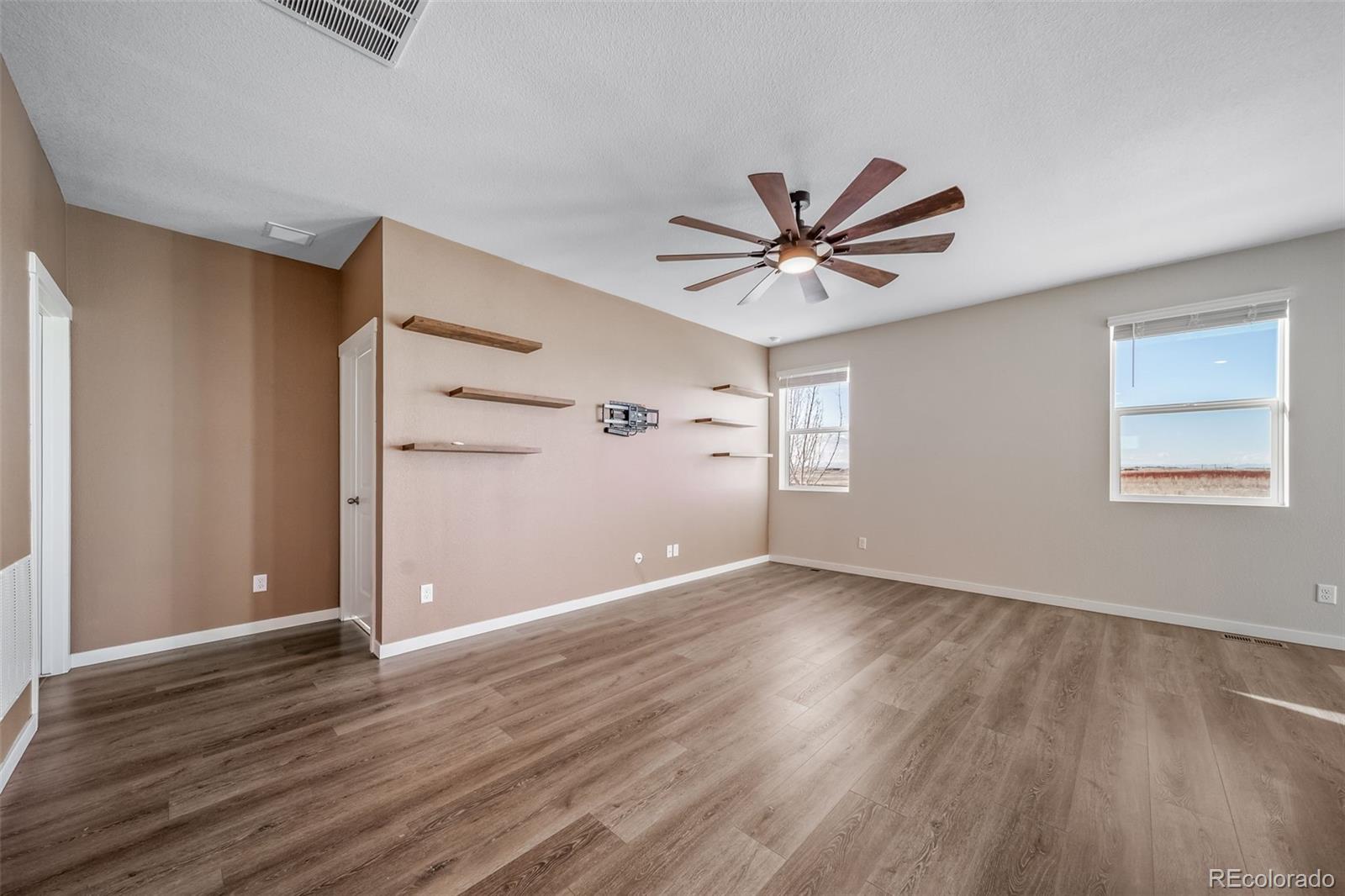 3018 Belleville Ridge Road Elizabeth, CO 80107 - Photo 10 of 32 an empty room with wooden floor and windows