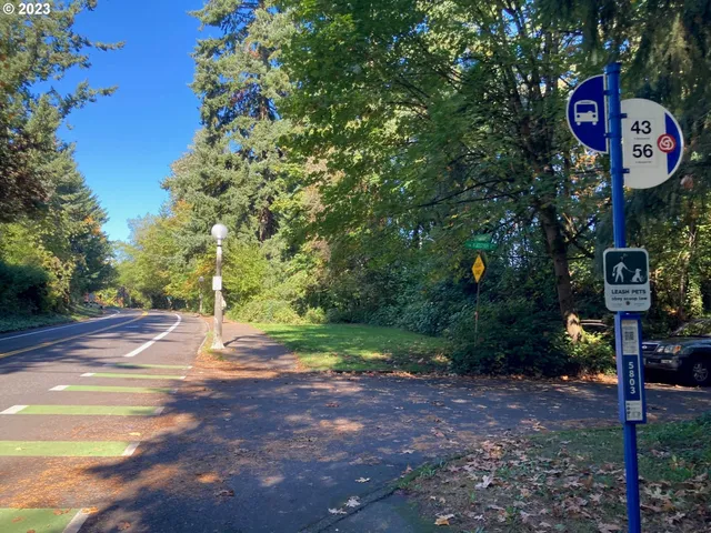 a street sign on a sidewalk next to a road