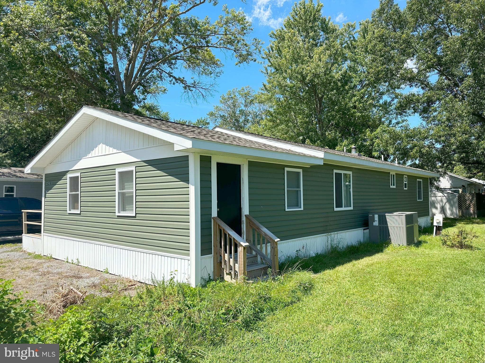 31743 Siham Road Lewes, DE 19958 - Photo 3 of 12 a side view of a house with a yard and chairs
