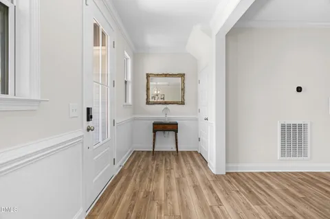 a view of a hallway with wooden floor and a living room