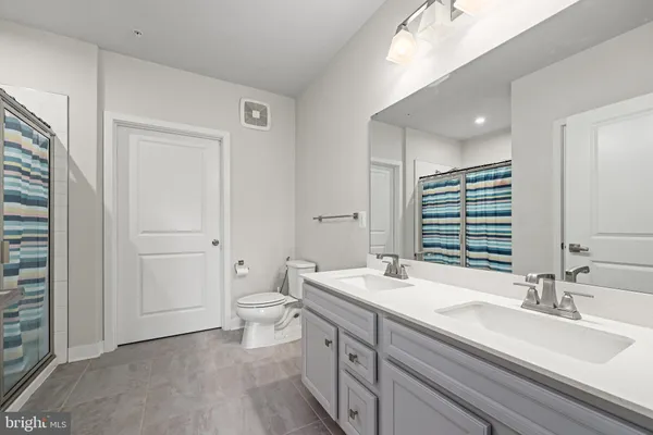 a bathroom with a double vanity sink mirror and toilet