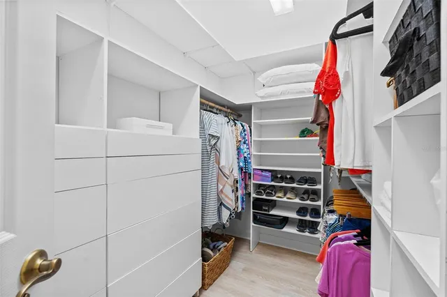 a view of walk in closet with clothes and shoes