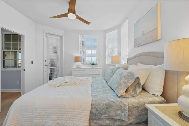 a bedroom with a large bed and a chandelier fan