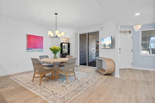 a dining room with furniture a chandelier and wooden floor