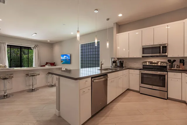 a kitchen with stainless steel appliances kitchen island granite countertop a sink and cabinets