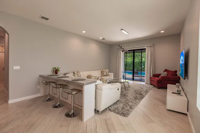 a living room with furniture a flat screen tv and a large window