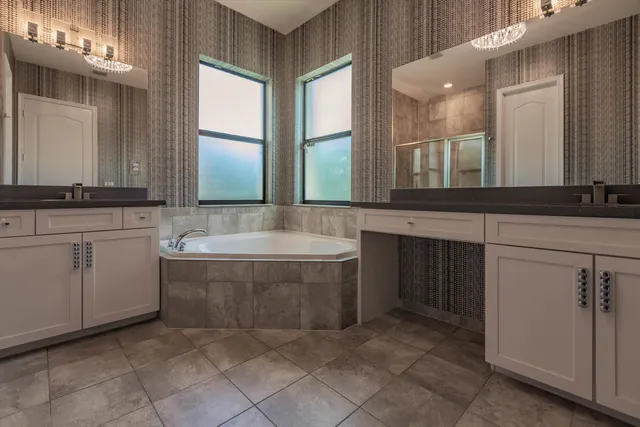 a bathroom with a granite countertop bathtub sink and mirror