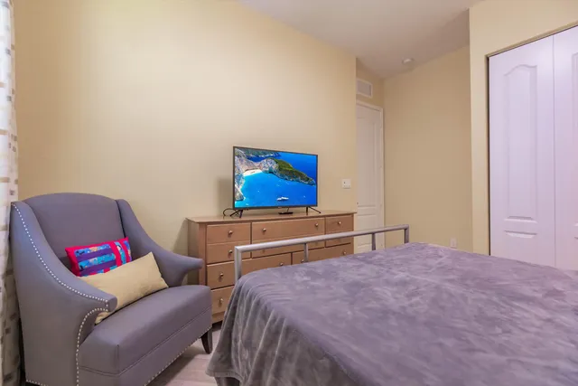 a bedroom with a bed and a flat screen tv