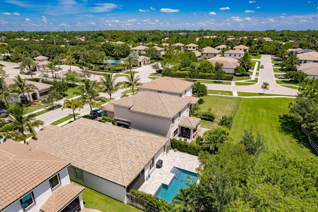 an aerial view of residential houses with outdoor space and ocean view