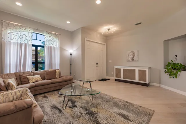 a living room with furniture a window and a potted plant