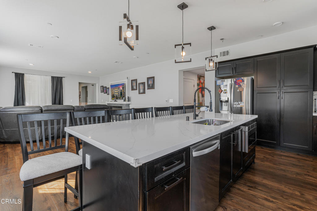 2820 Wagon Wheel Road, Unit 302 Oxnard, CA 93036 - Photo 7 of 26 a kitchen with kitchen island a sink stove and wooden floor