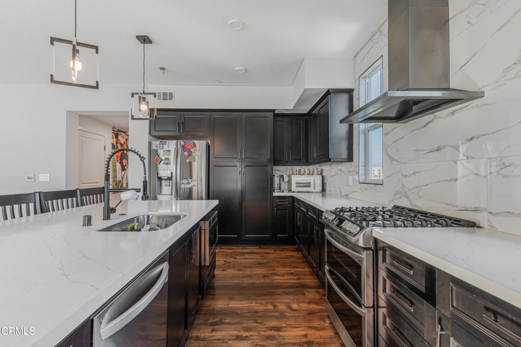 2820 Wagon Wheel Road, Unit 302 Oxnard, CA 93036 - Photo 8 of 26 a kitchen with kitchen island stainless steel appliances a sink stove and cabinets