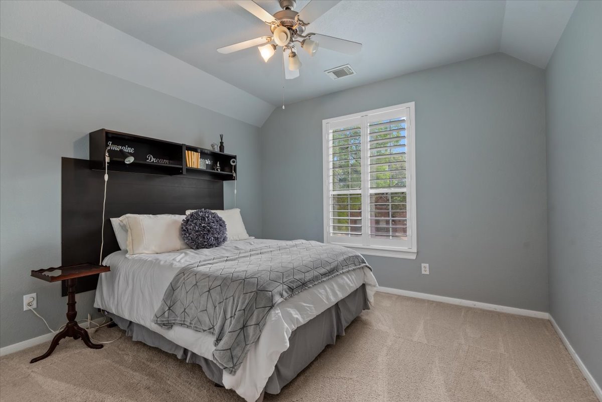 15519 Stallion Point Circle Cypress, TX 77429 - Photo 26 of 37 This room features vaulted ceilings, a ceiling fan with integrated lighting, and a window with white louvered shutters