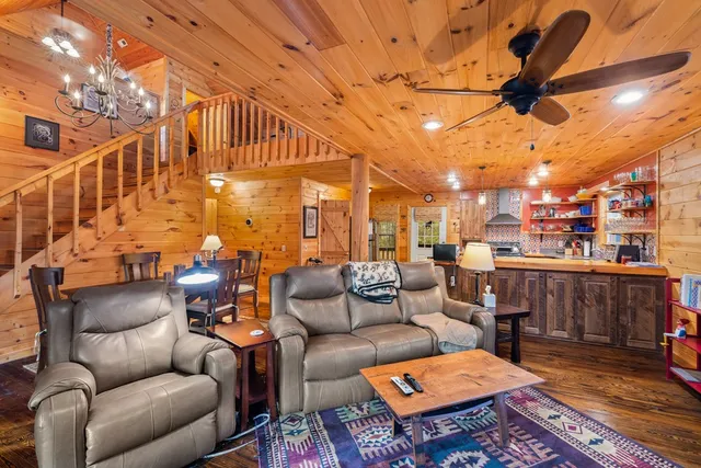 a living room with furniture a red rug and a chandelier