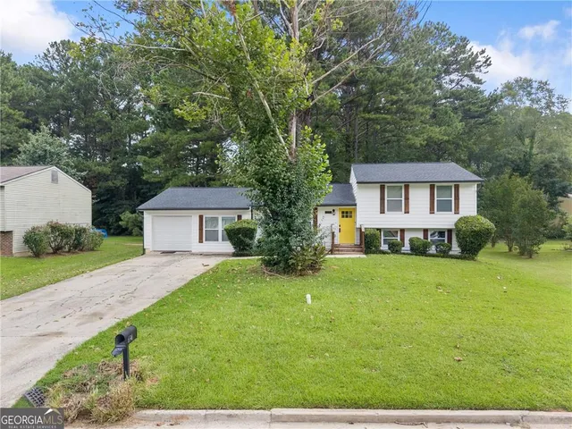 a front view of a house with yard and green space