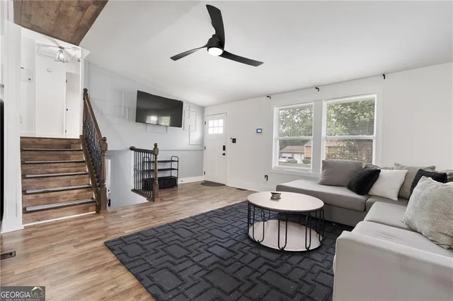 a living room with furniture and a wooden floor