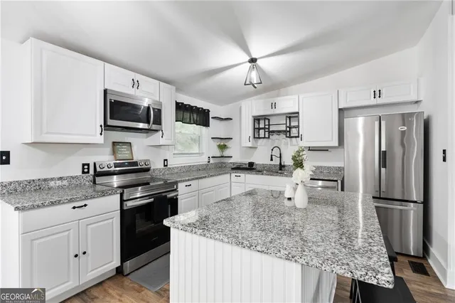a kitchen with stainless steel appliances granite countertop a refrigerator stove microwave and sink