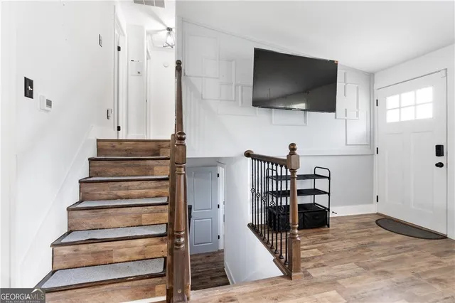 a view of entryway and hall with wooden floor