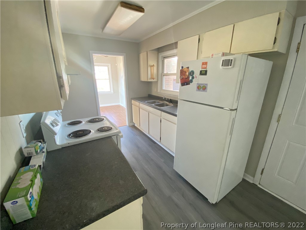 3518 Drayton Road Fayetteville, NC 28303 - Photo 8 of 17 a kitchen with stainless steel appliances granite countertop a refrigerator a stove a sink a washer dryer and white cabinets