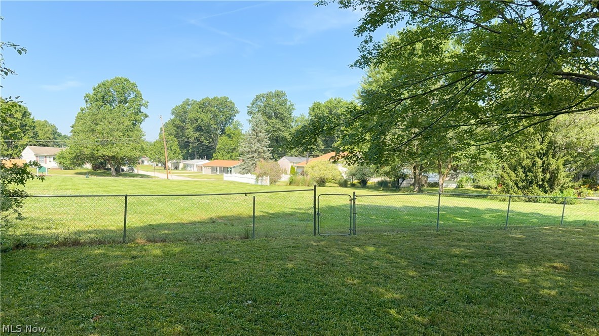 3796 North Santom Road Stow, OH 44224 - Photo 24 of 30 Expansive green lawn with established trees and a chain-link fence