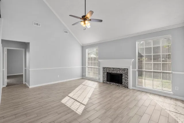 wooden floor fireplace and windows in an empty room
