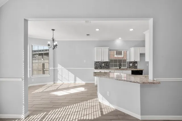 a kitchen with stainless steel appliances kitchen island granite countertop a refrigerator and a sink