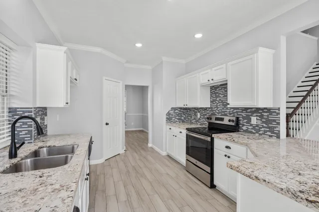 a kitchen with stainless steel appliances granite countertop a sink stove and refrigerator