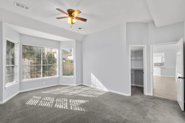 a view of a room with a window and a ceiling fan