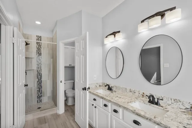 a bathroom with a granite countertop sink mirror and shower