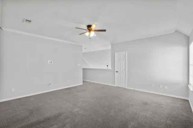an empty room with a ceiling fan and a window