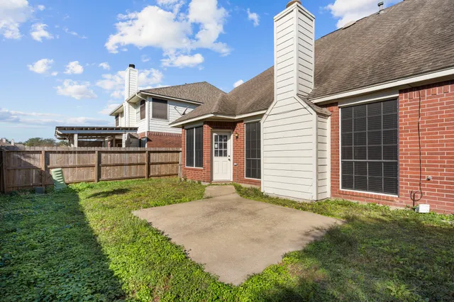 a view of backyard with potted plants and large tree