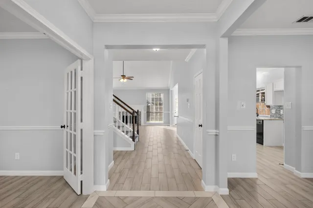 a view of a hallway with wooden floor and staircase