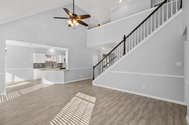 a view of a livingroom with wooden floor and a ceiling fan