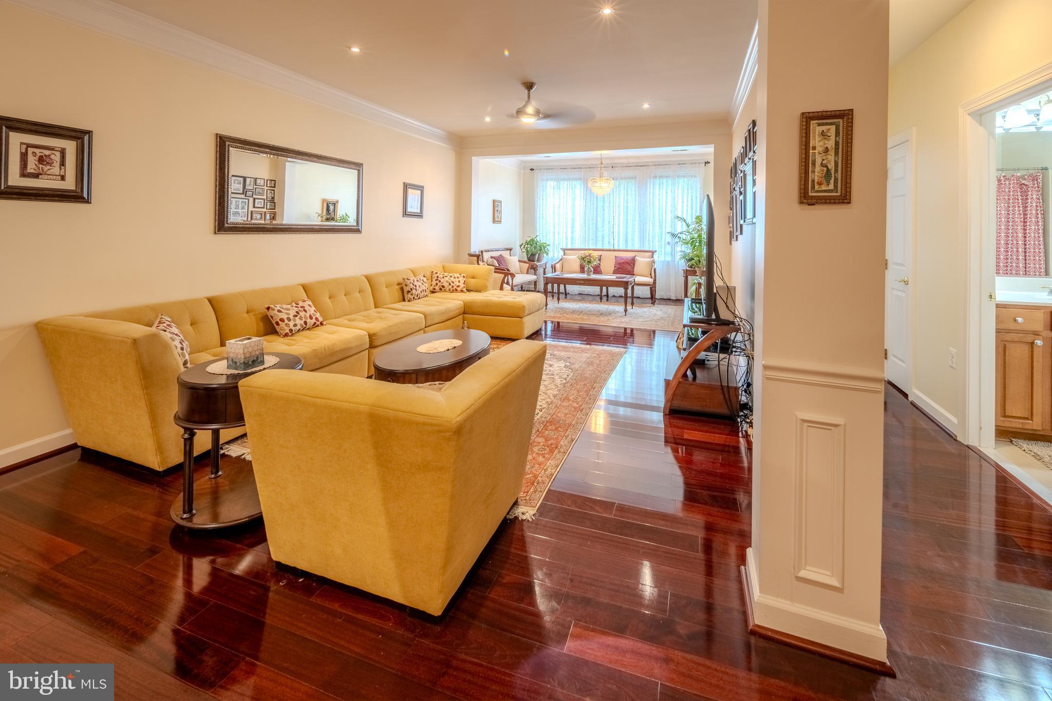 a living room with furniture wooden floor and a large window