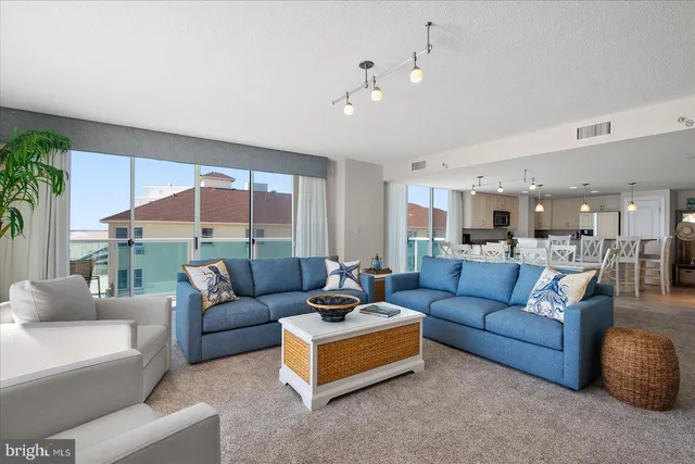 a kitchen with kitchen island granite countertop a stove a sink a oven and a dining table with wooden floor