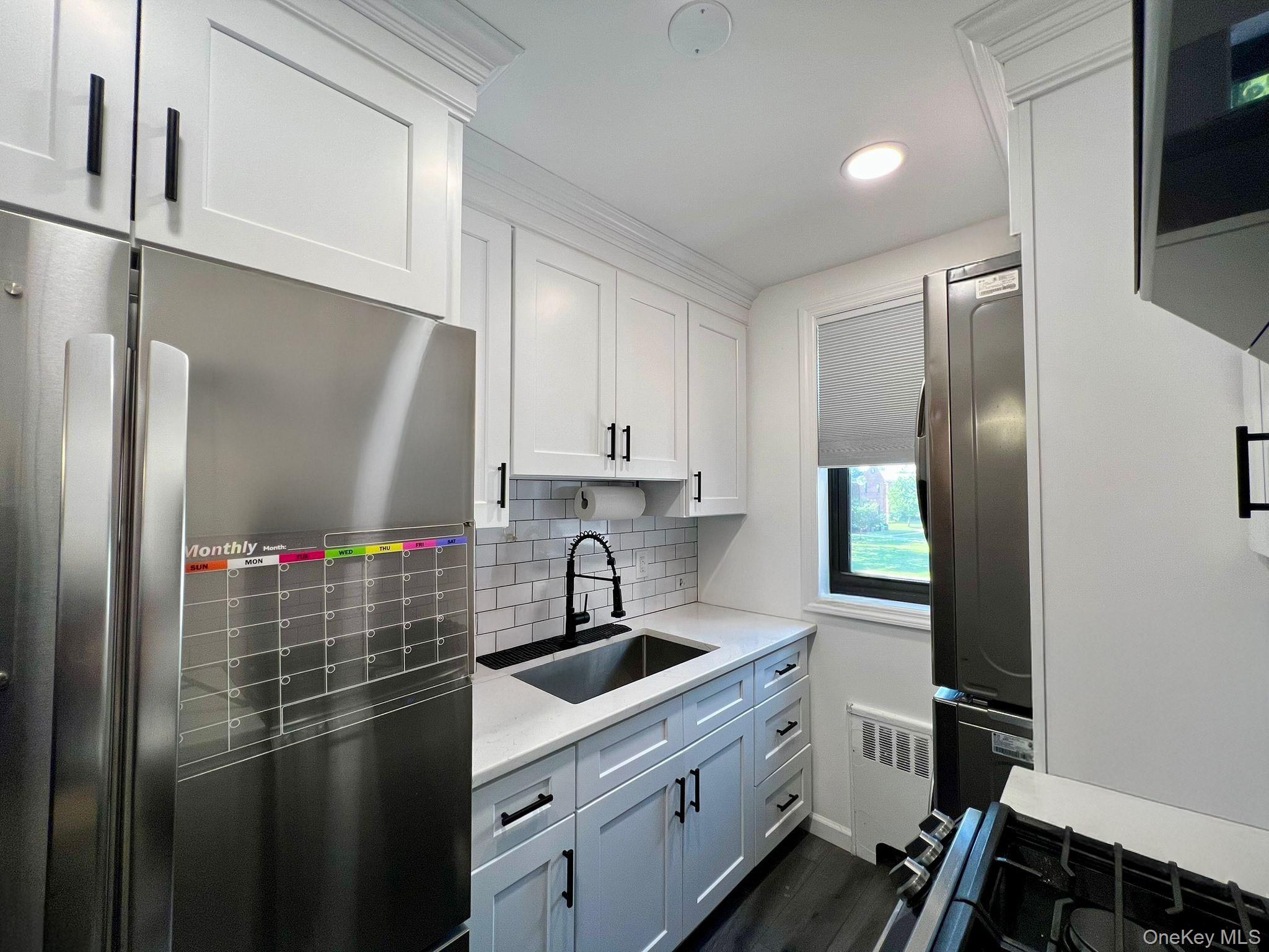 17-72 166th Street, Unit 2 Queens, NY 11357 - Photo 9 of 13 a kitchen with kitchen island a sink stainless steel appliances and cabinets
