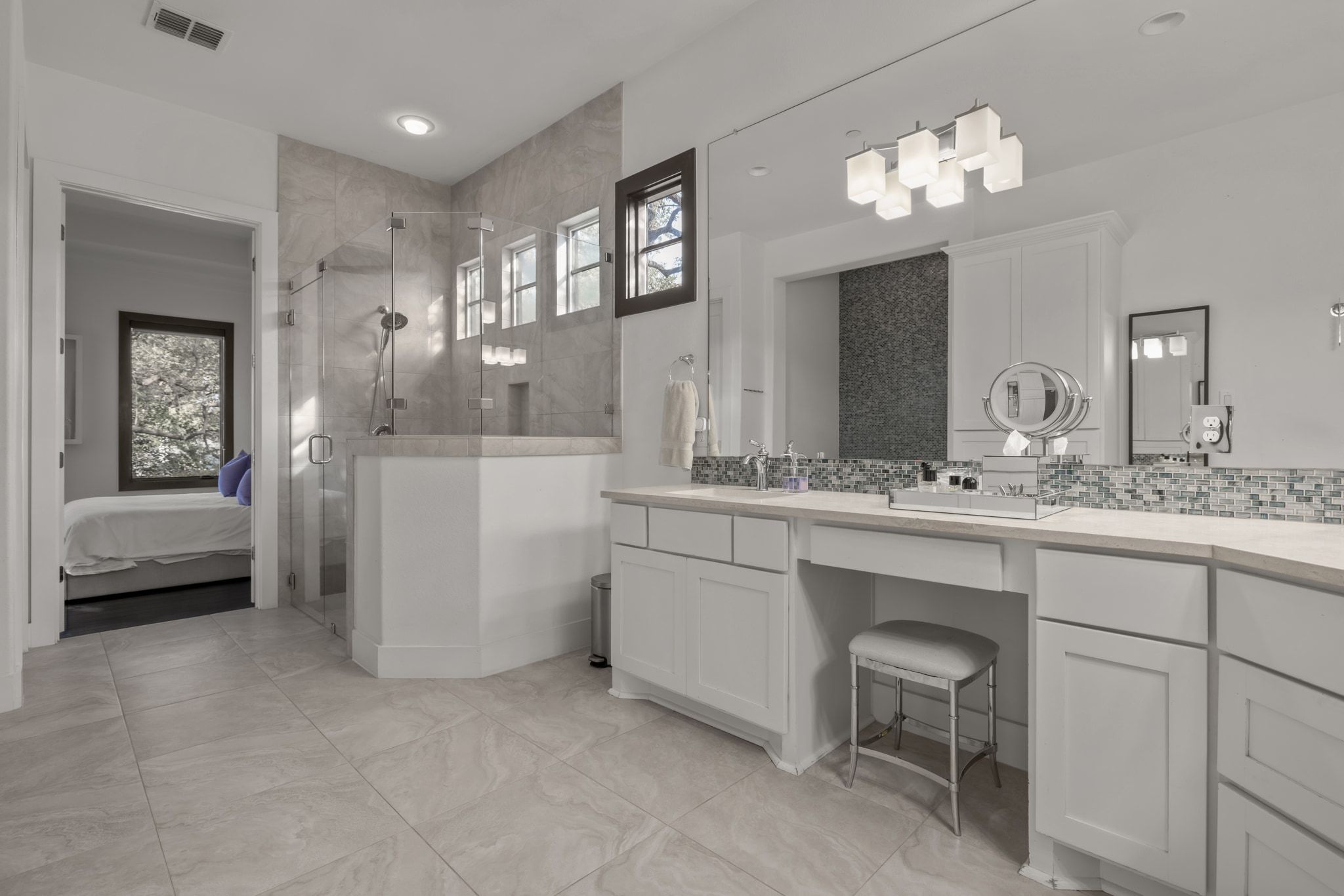 4720 Rockcliff Road, Unit 1 Austin, TX 78746 - Photo 23 of 39 A generously sized primary bathroom features a tiled shower and an extensive double vanity with ample counter space.