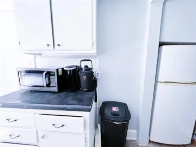 a kitchen with granite countertop a refrigerator and a sink