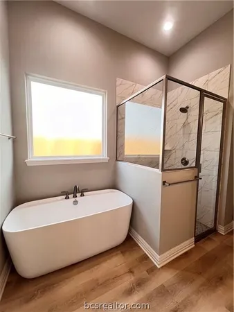 a bathroom with a white tub shower vanity and a sink