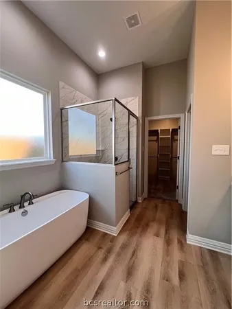 a spacious bathroom with a double vanity sink and a tub