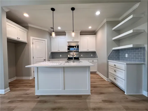 a kitchen with kitchen island a sink stainless steel appliances and cabinets