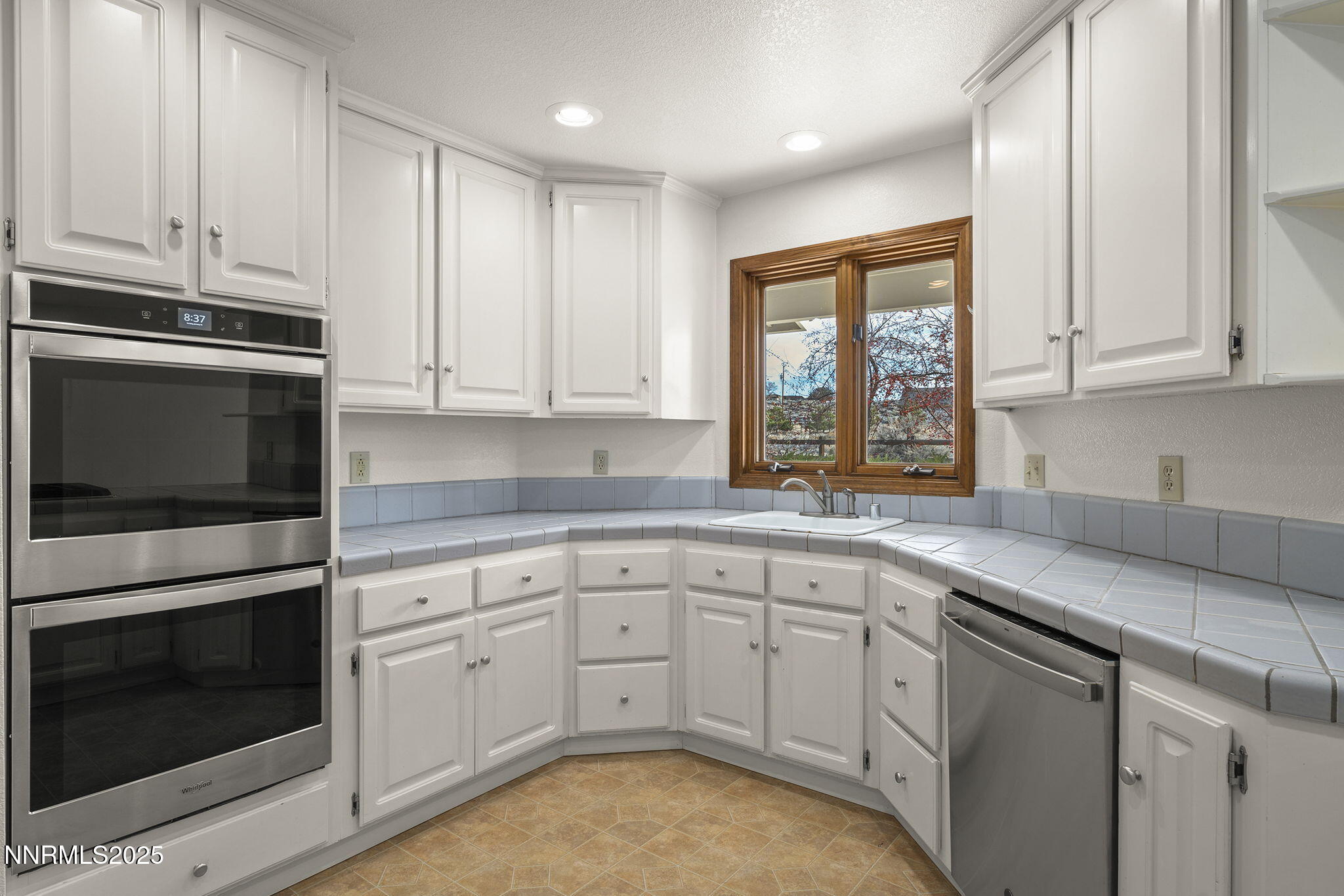 1653 Dees Lane Minden, NV 89423 - Photo 12 of 36 a kitchen with granite countertop white cabinets stainless steel appliances and a window