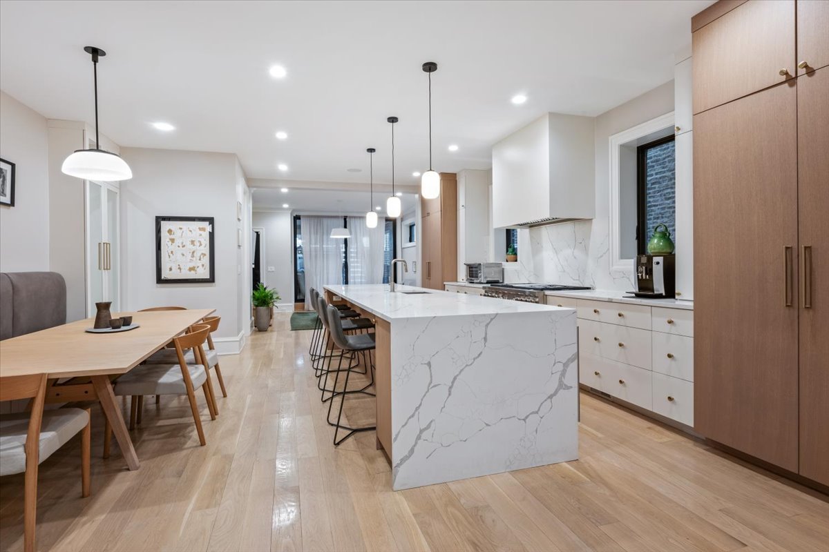 2212 North Halsted Street, Unit 1 Chicago, IL 60614 - Photo 10 of 38 a kitchen with white cabinets and chairs