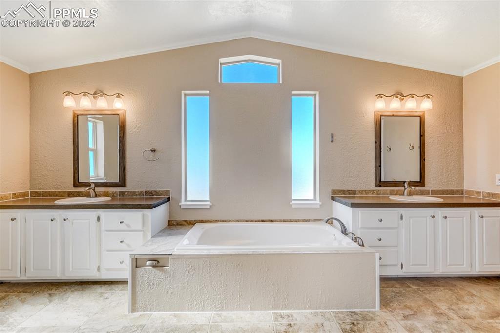 6240 Night Train Lane Yoder, CO 80864 - Photo 29 of 50 a bathroom with a tub sink and mirror