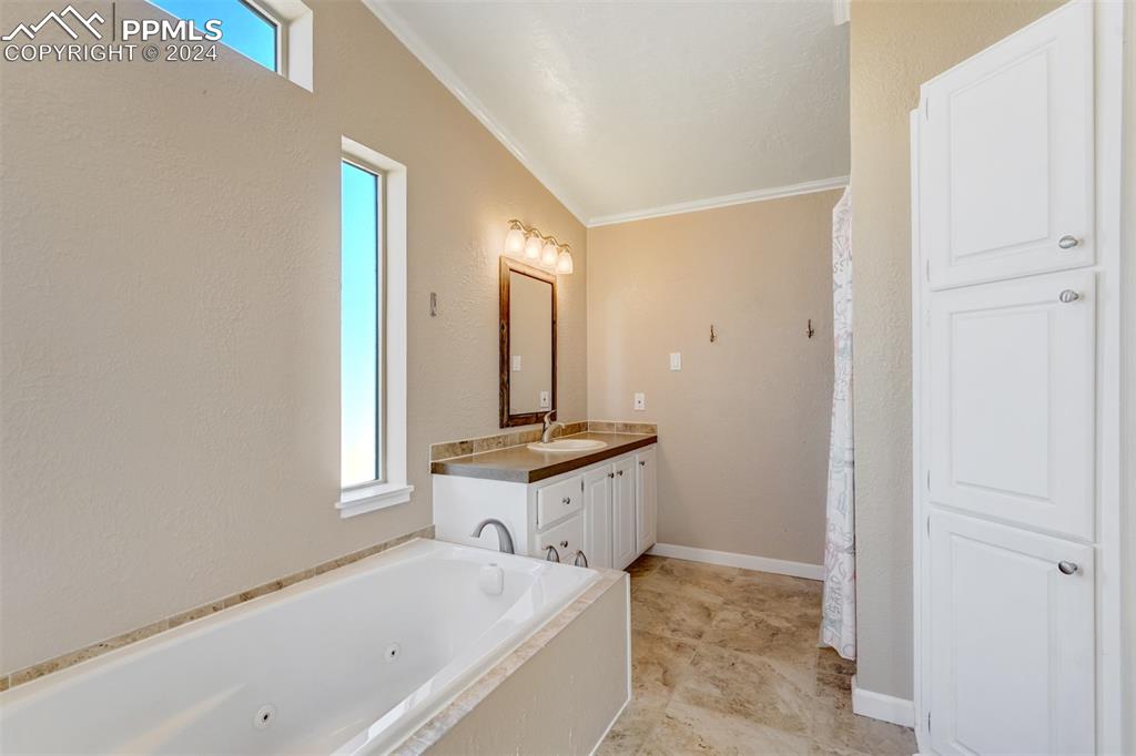 6240 Night Train Lane Yoder, CO 80864 - Photo 30 of 50 a bathroom with a tub sink and mirror